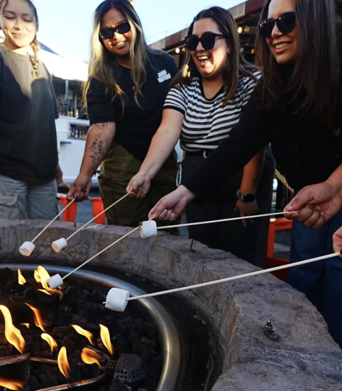 Neighbors roasting marshmallows together at a fire pit